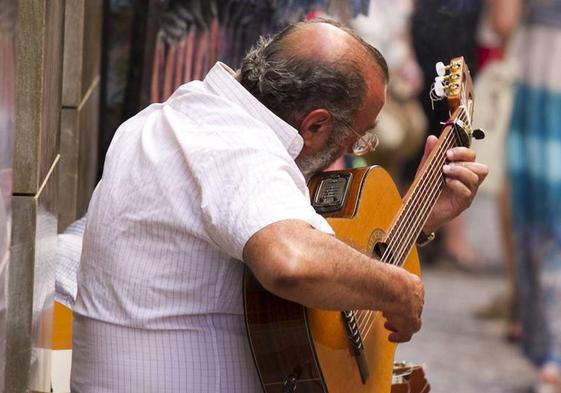 Un guitarrista tocando en la calle.