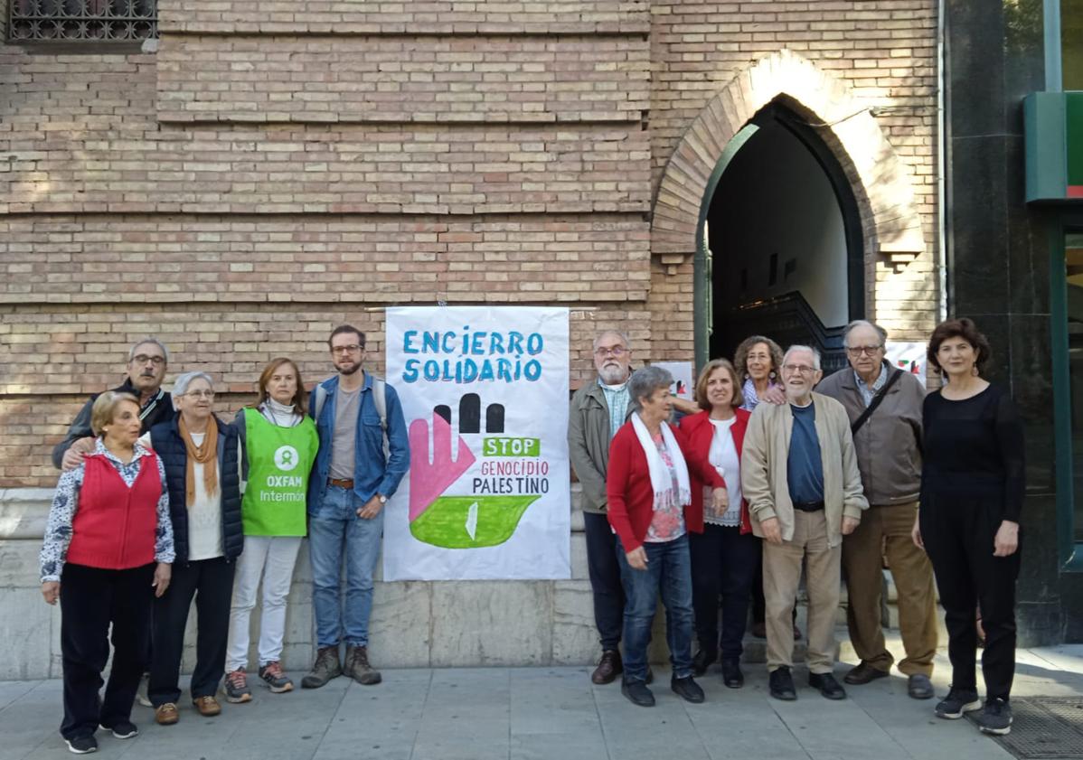 Imagen principal - El grupo del encierro, en el exterior y el interior del local, leyendo el manifiesto. 