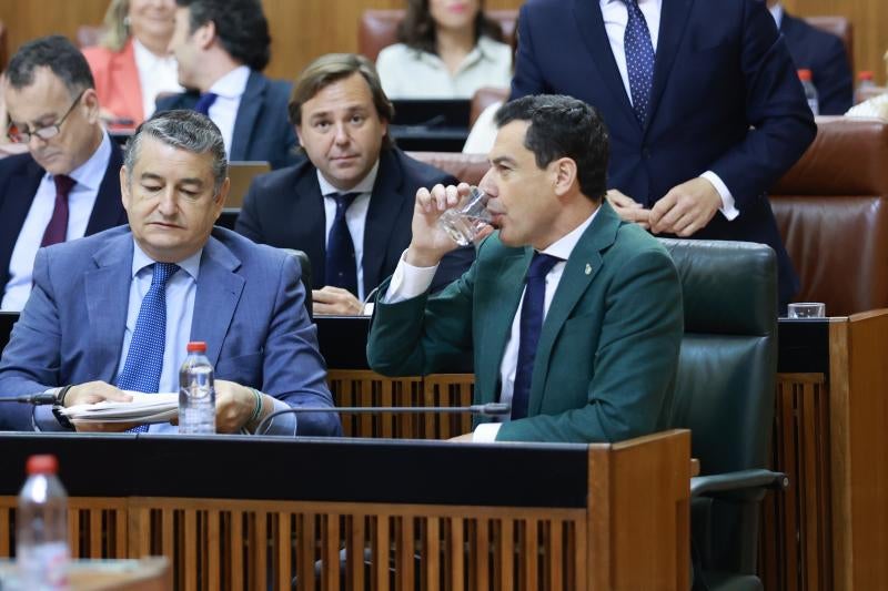 El presidente de la Junta de Andalucía, Juanma Moreno, bebe agua tras una intervención este jueves en el Parlamento andaluz