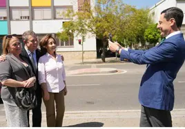 El presidente andaluz fotografía a su homónimo de Castilla La Mancha con dos vecinas de Sevilla.