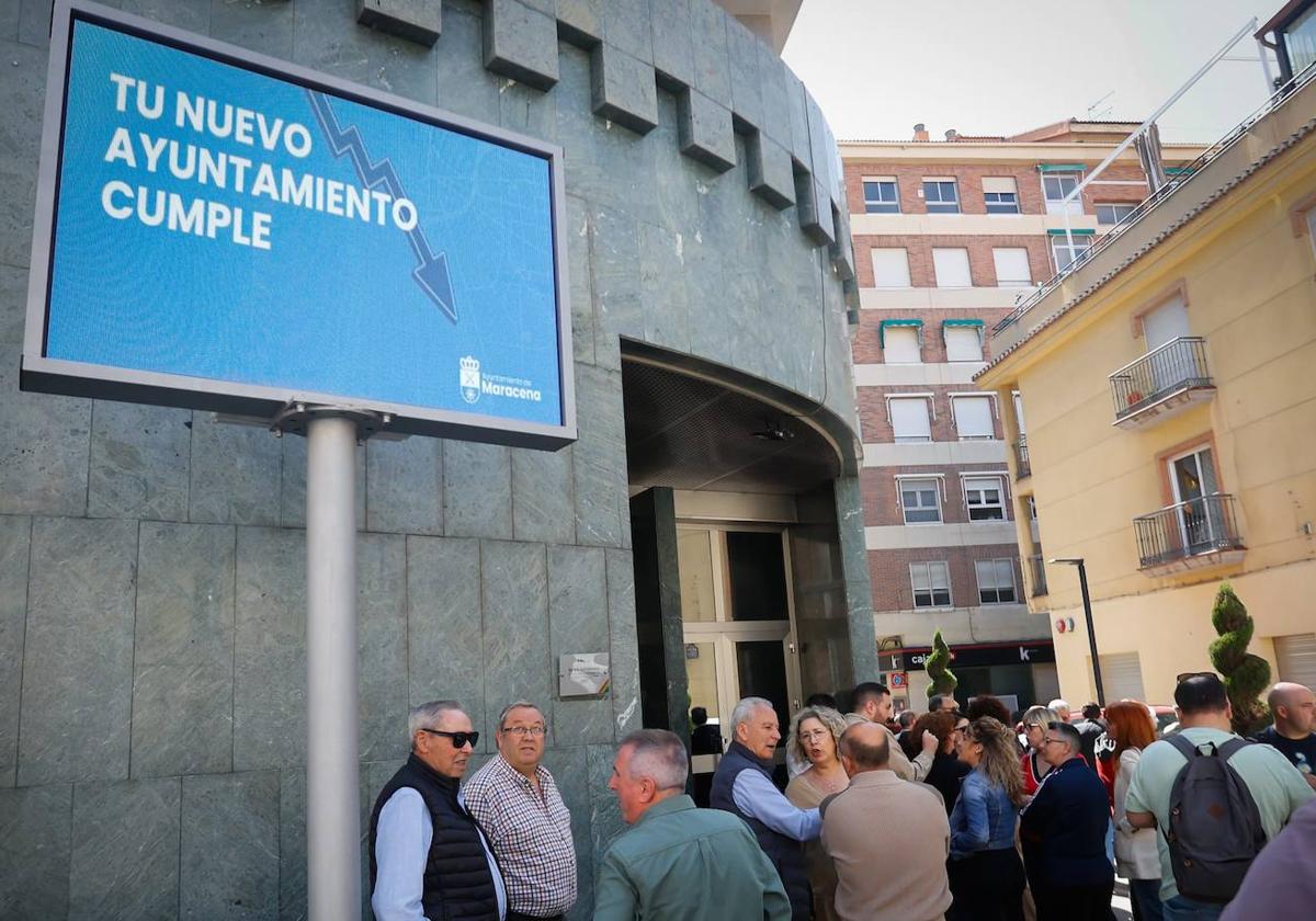 Expectación este sábado en Maracena ante un pleno extraordinario que no se celebró, bajo un letrero que dice 'tu nuevo Ayuntamiento cumple«