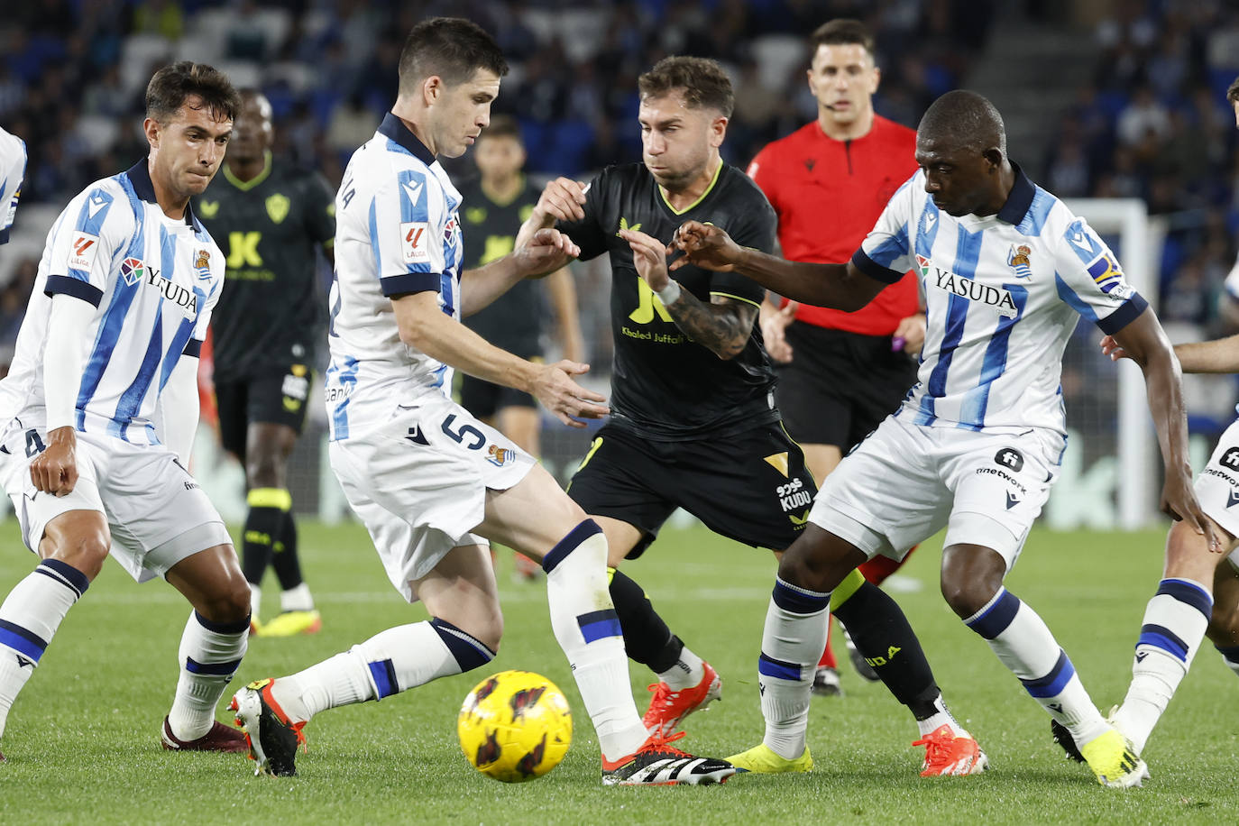 Adrián Embarba, entre Zubeldia y Traoré, se maneja con el balón para escapar.