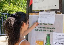 Una estudiante consulta un anuncio de un piso en alquiler en Granada.