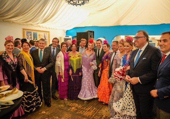 Juanma Moreno, con miembros de su gobierno y otros dirigentes, ayer en la caseta del PP de la Feria de Sevilla.