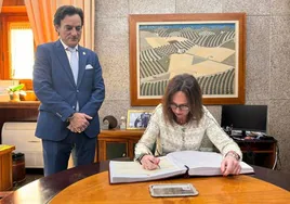 La consejera, Rocío Díaz, firma en el libro de honor del Ayuntamiento.