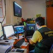 Un guardia civil utiliza varios ordenadores para investigar ciberdelitos.