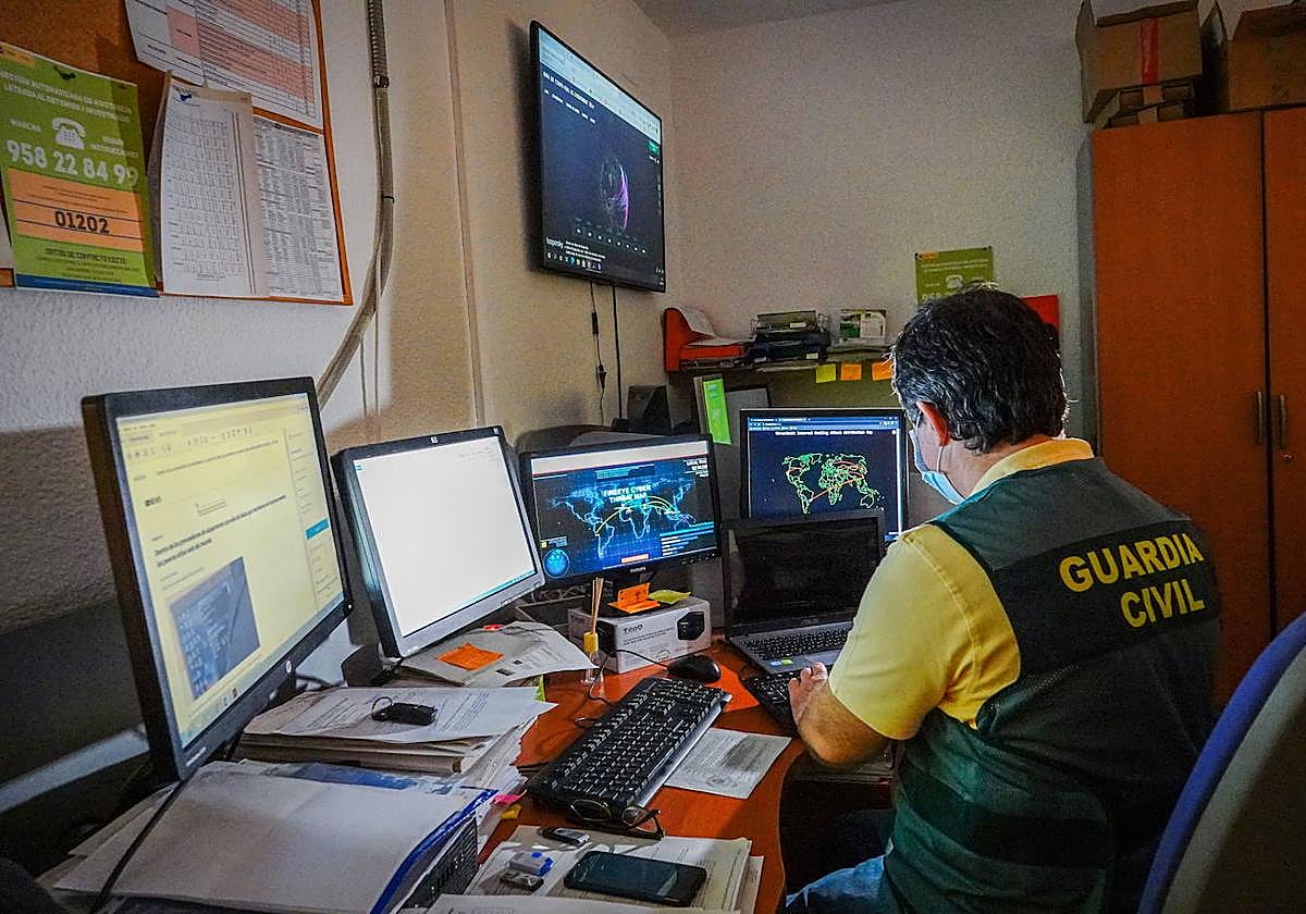 Un guardia civil utiliza varios ordenadores para investigar ciberdelitos.