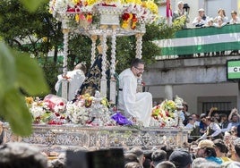 Menores se acercan a la Virgen aupados por los fieles durante la procesión.