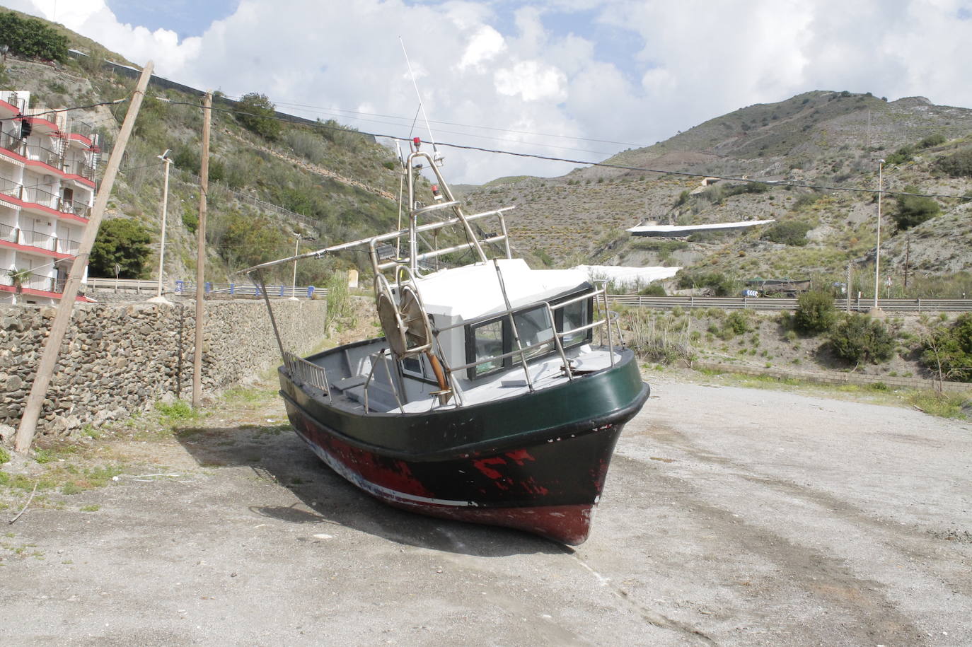 El barco, en depósito en un solar que se emplea como aparcamiento en verano.