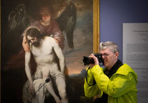 Fotógrafo delante de la obra prestada por el Prado, 'Cristo muerto sostenido por un ángel'.