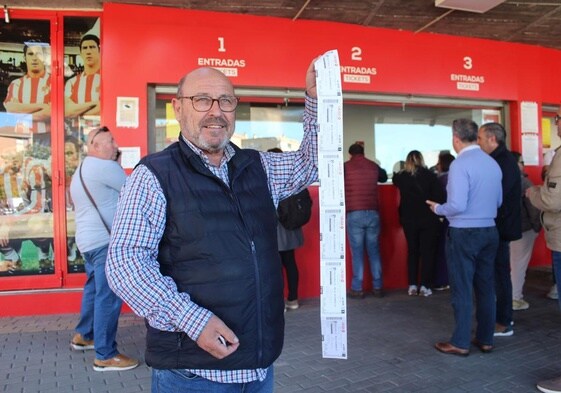 Un abonado del Granada muestra una ristra de entradas para el partido.