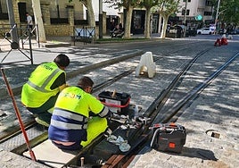 Operarios de Alstom revisan los motores del cambio de vía, al inicio del trazado.