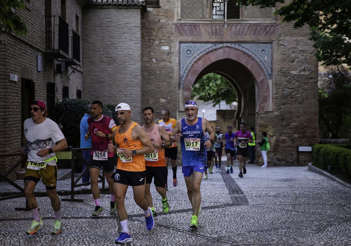 Paso de un grupo de corredores por el interior de la Alhambra.