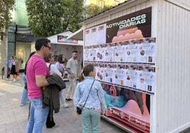 una familia mira la programación diaria de actividades de la Feria del Libro.