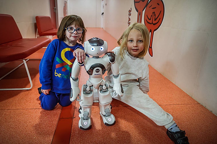 Guiomar y su hermano Darío con el robot terapéutico Juande.