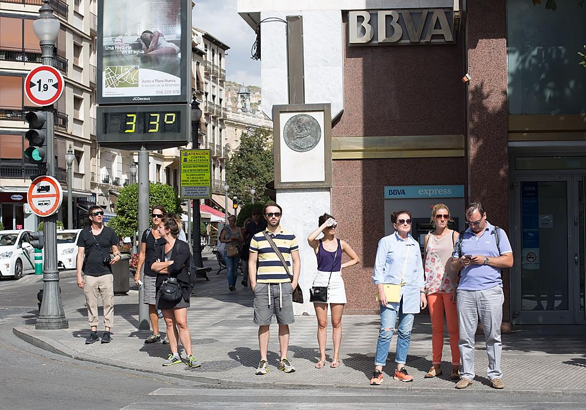 Turistas y granadinos, junto al termómetro de Reyes Católicos poco antes del verano.