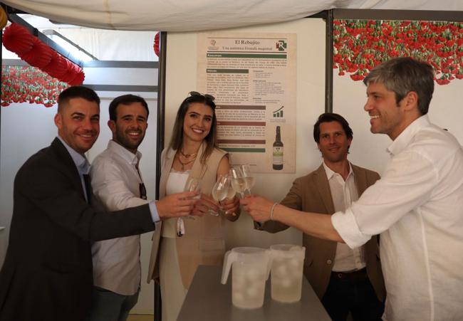 Brindis junto al cartel de la fórmula magistral del rebujito.