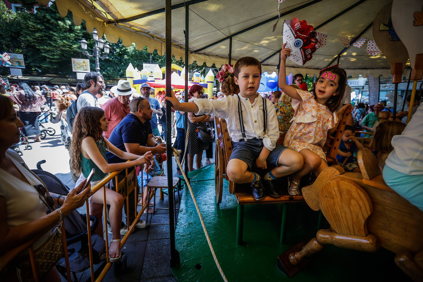 Niños en el carrusel de madera de Bib Rambla en el día del Corpus.