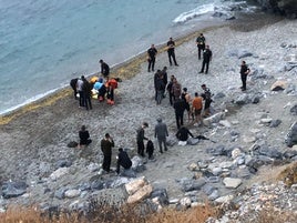 Los inmigrantes, junto a agentes de la Guardia Civil en la playa donde han desembarcado.