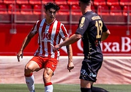 Paco Sanz controla el balón en presencia de Migue García.