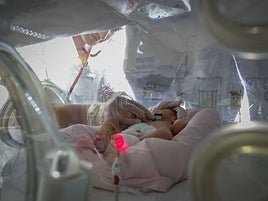 Una pediatra atiende a un bebé en la incubadora.