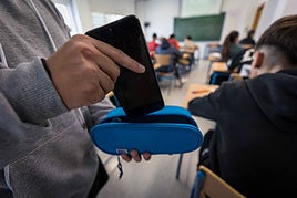 Un adolescente saca su móvil del estuche en una imagen de archivo.