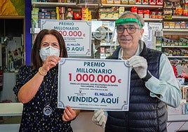 Dos loteros mostrando el premio millonario de Euromillones concedido en su establecimiento.