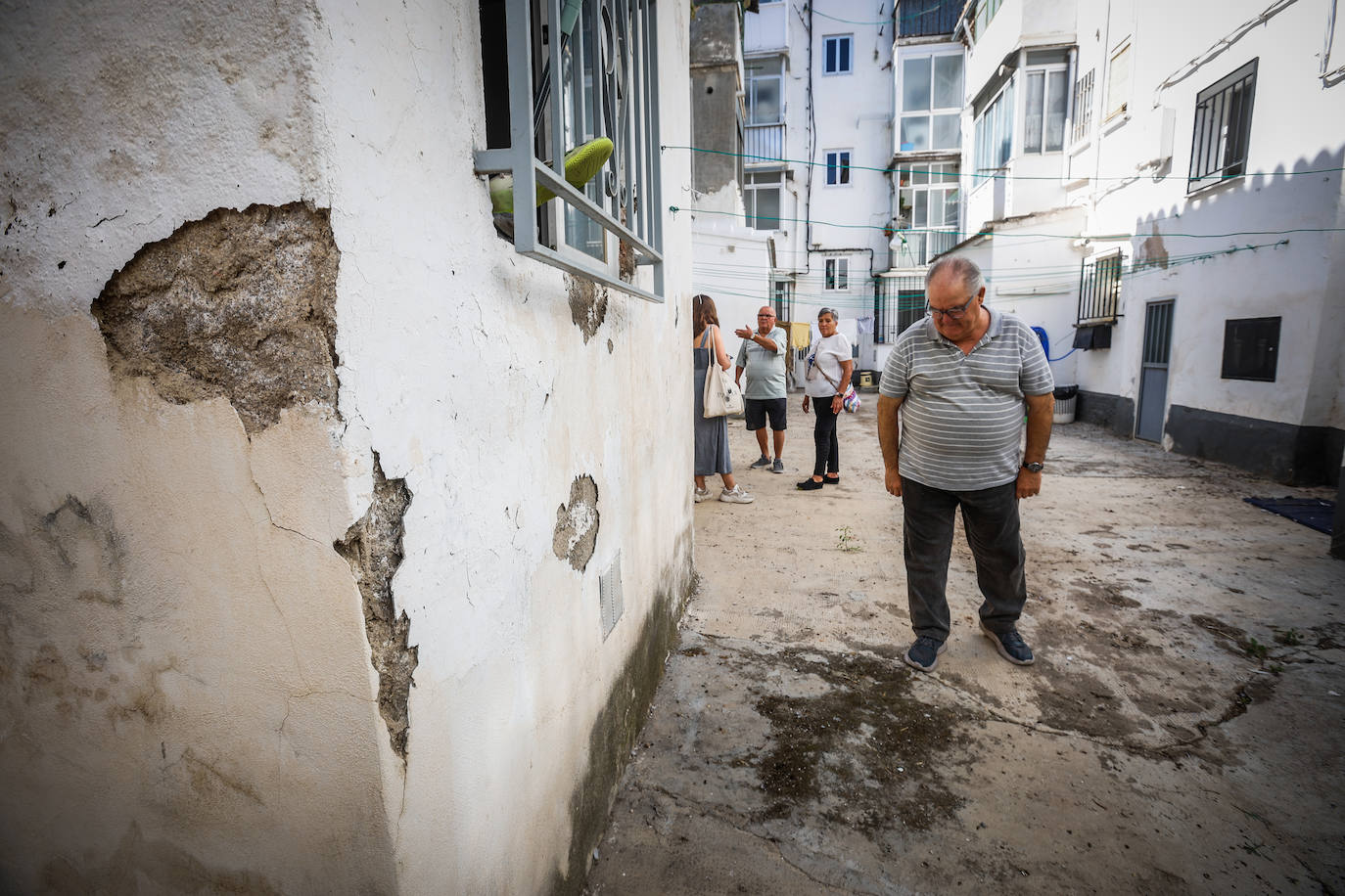 Vecinos de Santa Adela en uno de los patios con humedades y fachadas desconchadas.