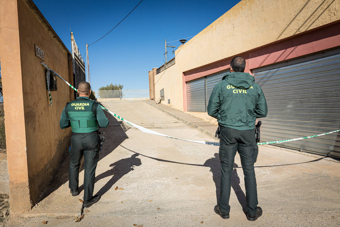 Dos agentes de la Guardia Civil observan la calle en la que apareció el cadáver.