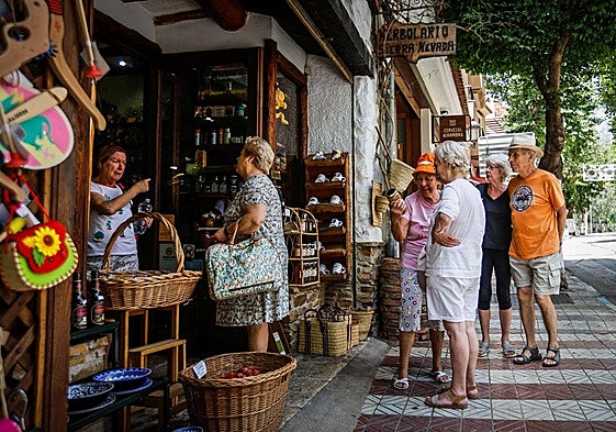 Un grupo de turistas hace cola frente a una tienda de regalos y productos típicos de Lanjarón el pasado viernes.