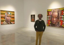 Román, entre los retratos de tres mujeres.