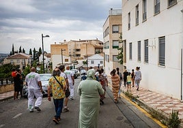 Vecinos regresando a sus pisos después de que la Guardia Civil se llevara detenido al hombre que se atrincheró en su casa de La Zubia.