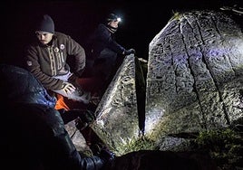 Investigadores, provistos de frontales, analizan el impresionante petroglifo hallado en Sierra Nevada.