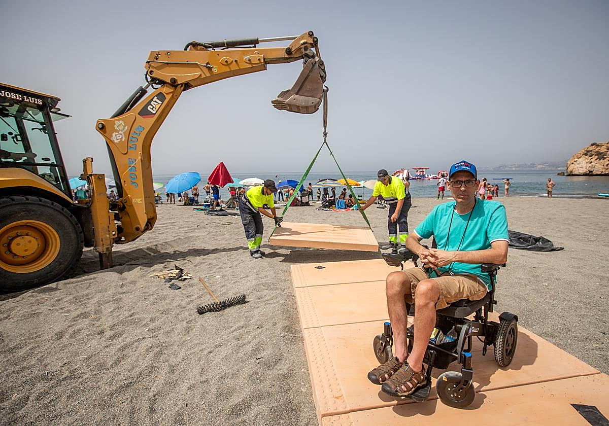 Marcelino junto a la máquina y operarios colocando las pasarelas de hormigón de acceso a la playa.