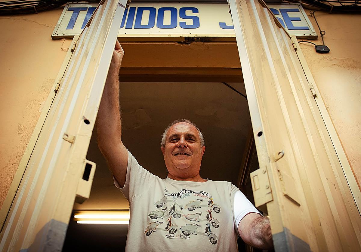 José posa en la puerta de su negocio.