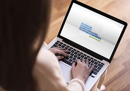 Una mujer observa una web defectuosa en su ordenador portátil.