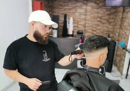 Juan Antonio, realizando un corte de pelo a un cliente.