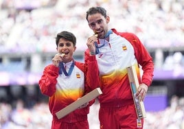 María Pérez y Álvaro Martín muerden sus medallas de oro en la ceremonia de premiación en París.