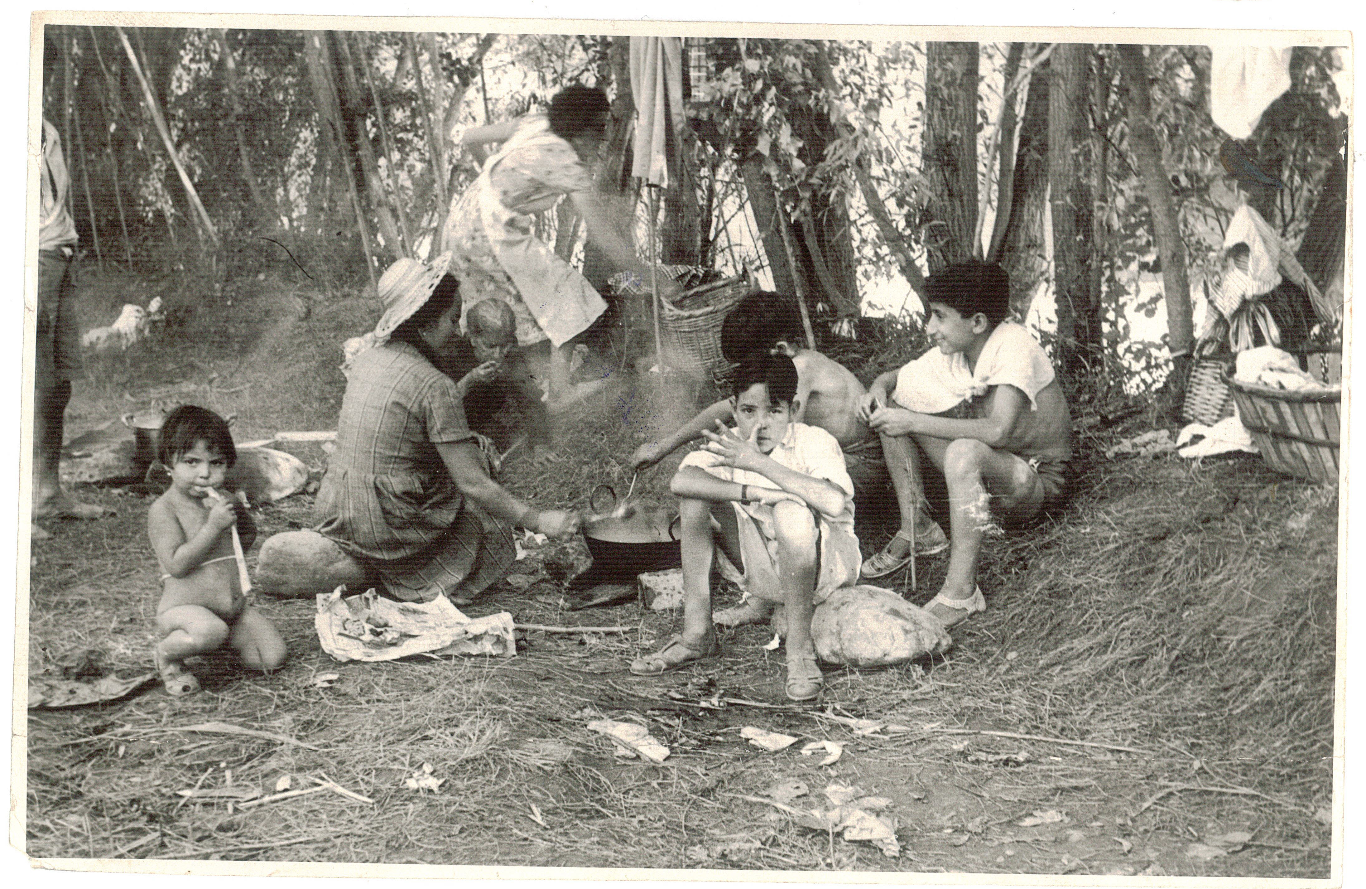 Una familia prepara la comida junto al río