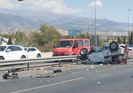 El coche grúa volcado en la Circunvalación de Granada.