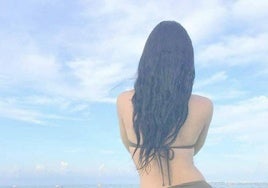 Casandra, colombiana que se gana la vida ejerciendo la prostitución, posa de espaldas en la playa.