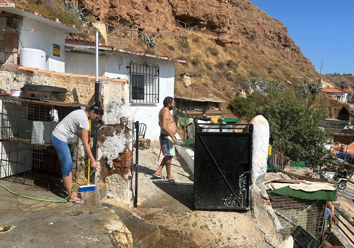 Vecinos de Beas de Guadix limpian las puertas de sus viviendas.