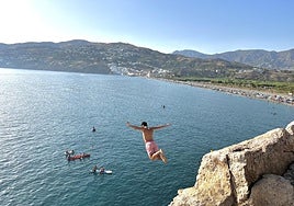 Un joven tirándose al agua por el peñón de Salobreña.