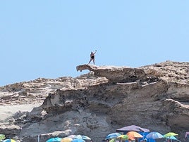Una mujer se toma un 'selfie' al borde de la duna fósil de Los Escullos.