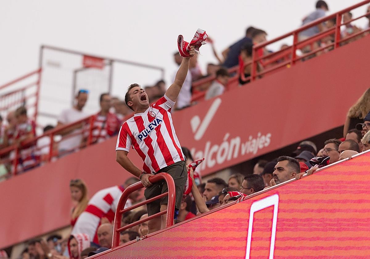 Un aficionado del Granada intenta que el resto anime durante el partido con el Deportivo.