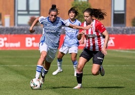 Alba Pérez, de blanquiazul, sube la pelota ante la marca de una futbolista del Athletic.