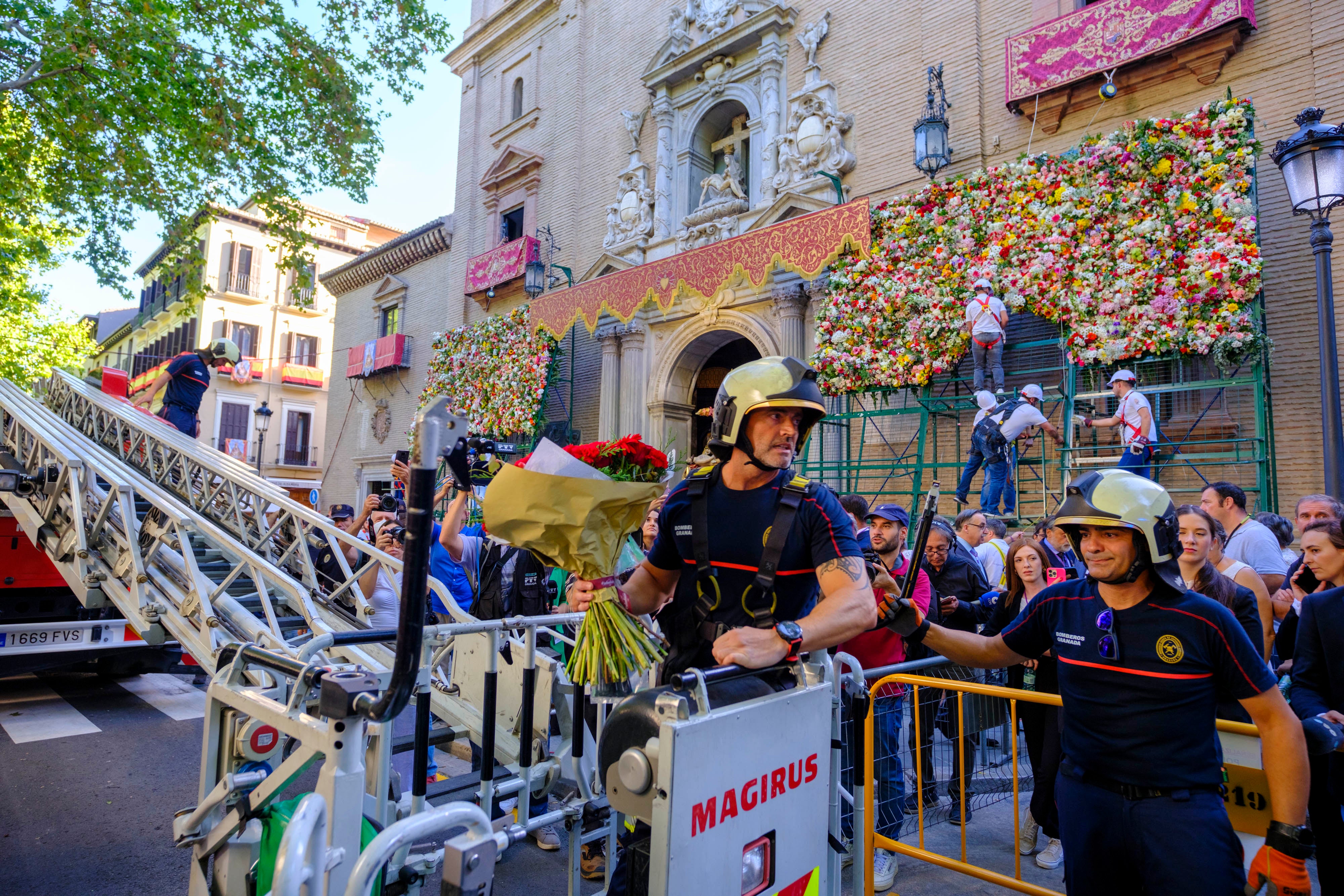 n miembro del Cuerpo de Bomberos se sube a la escala durante la ofrenda floral.