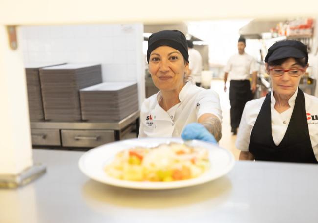 Una cocinera de los comedores sirve su primer menú del curso.