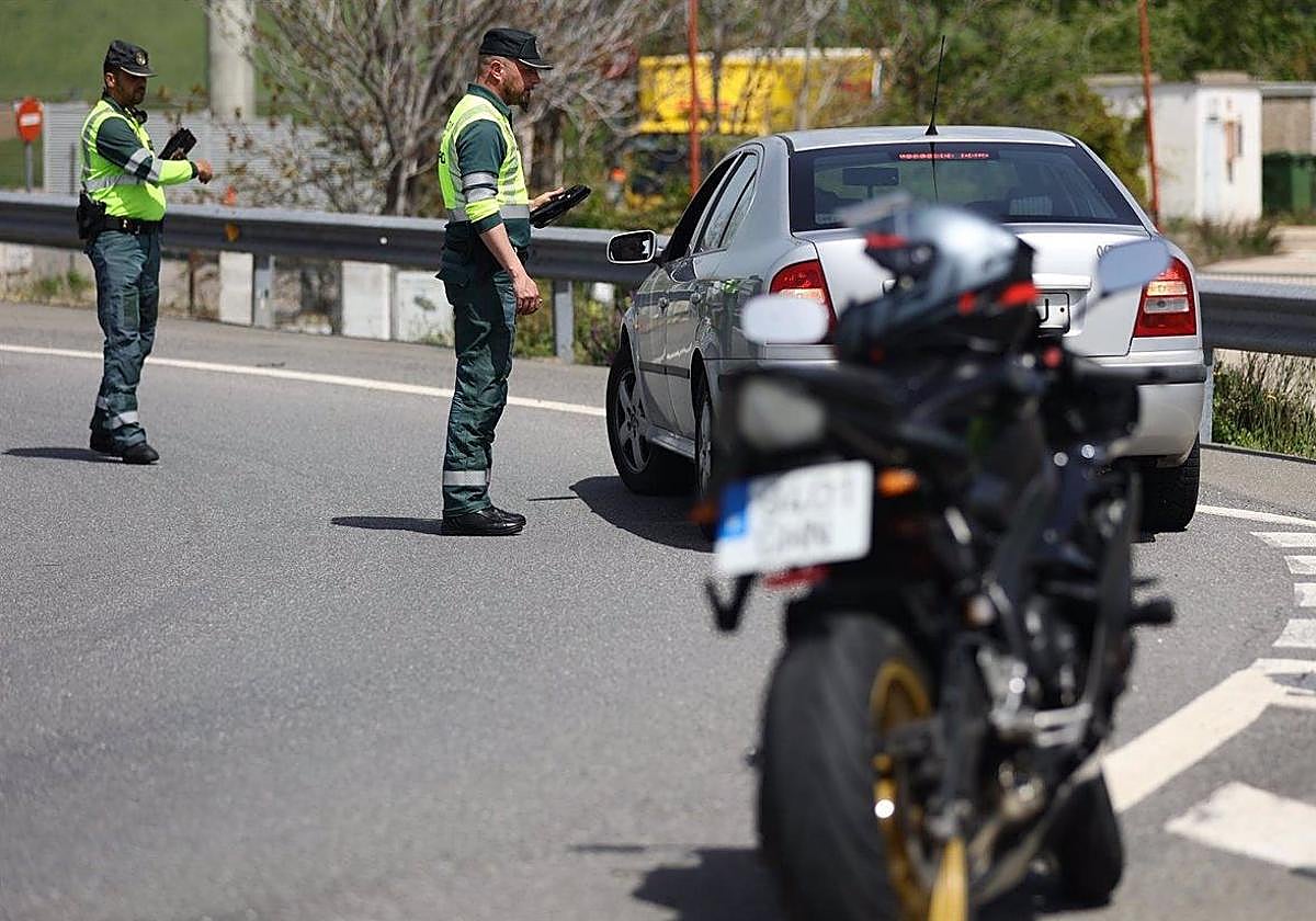 Un agente de la Guardia Civil pide documentación a un conductor en un control de tráfico.