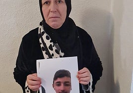 La madre de Adil muestra una foto de su hijo.